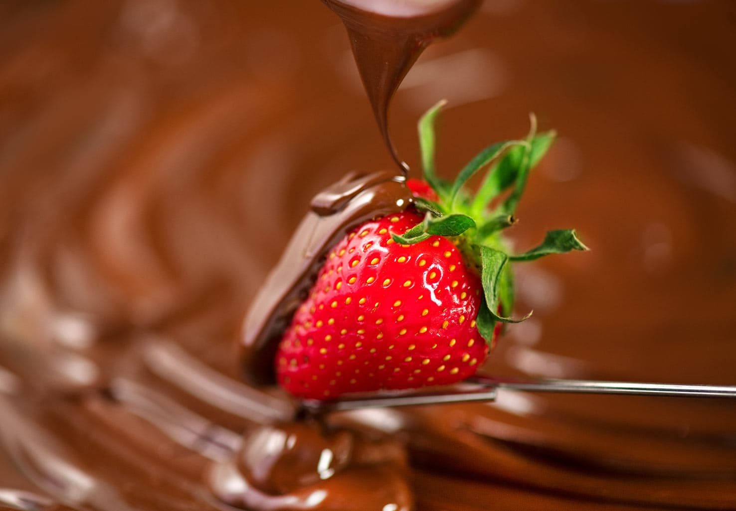 Strawberry being dipped with chocolate