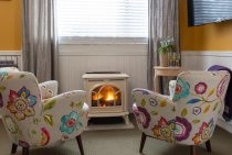 Two colorful chairs in front of fireplace