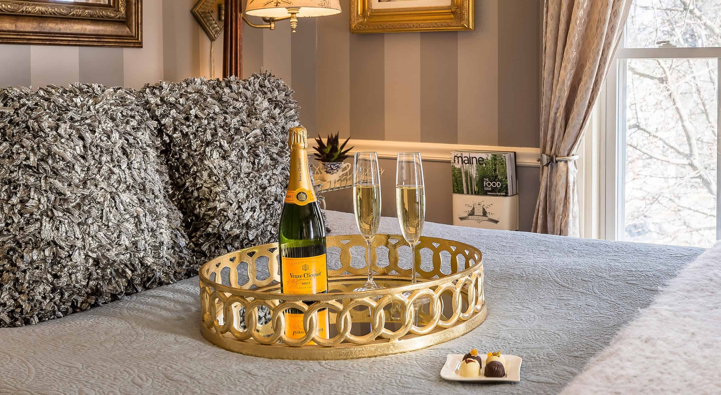 champagne and chocolates on a bed